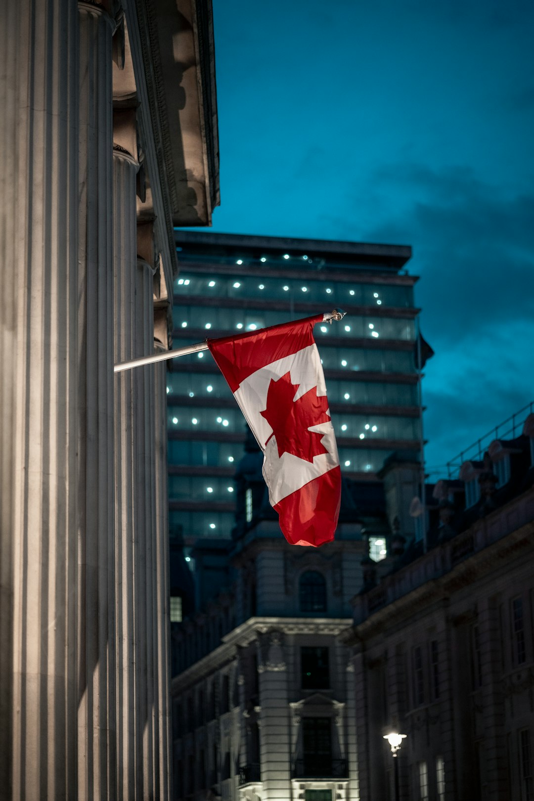 a-canadian-flag-hanging-from-the-side-of-a-building-ops8ldcawvo