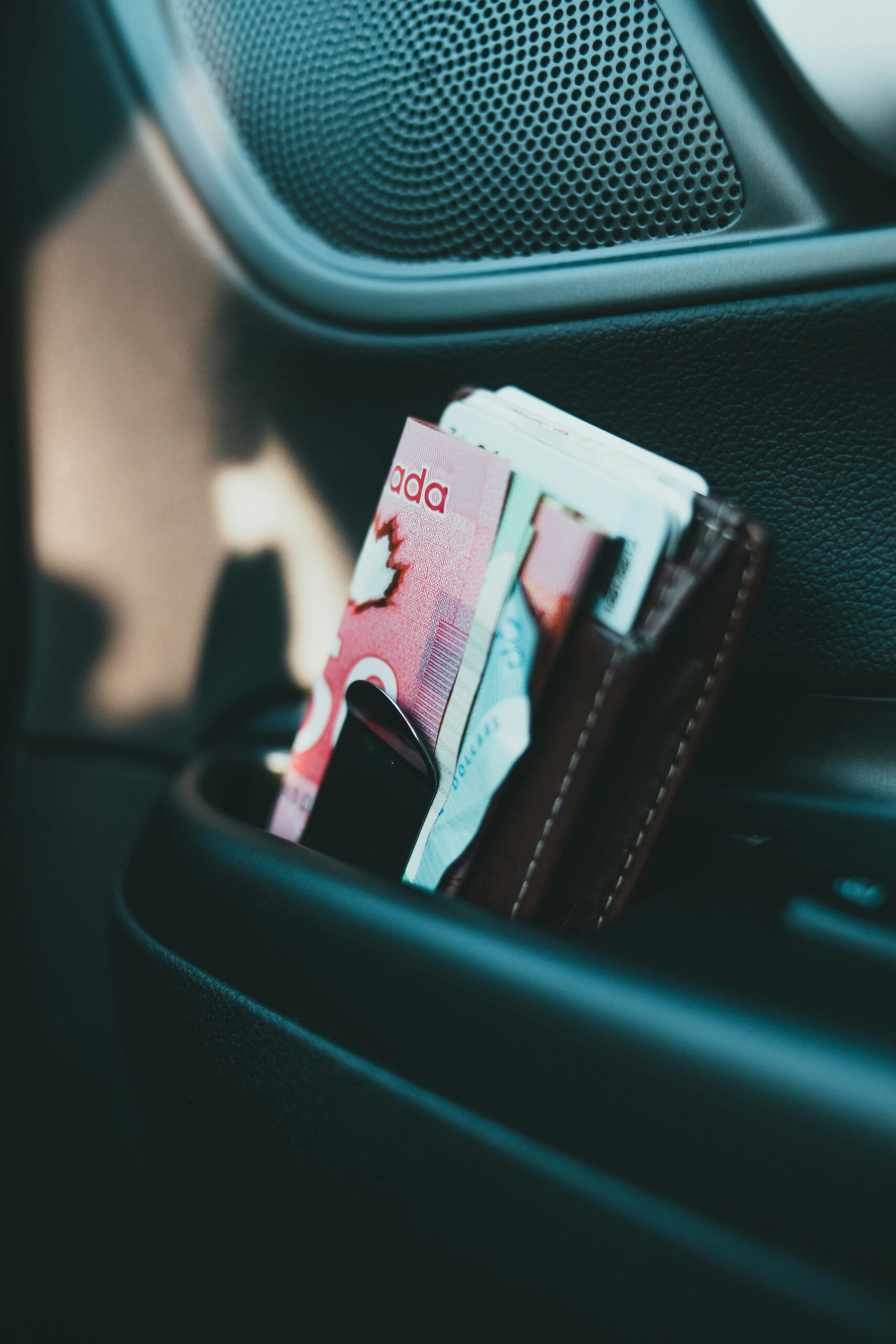 Canadian banknotes tucked in a wallet inside a car, illustrating urgent financial needs covered by a payday loan