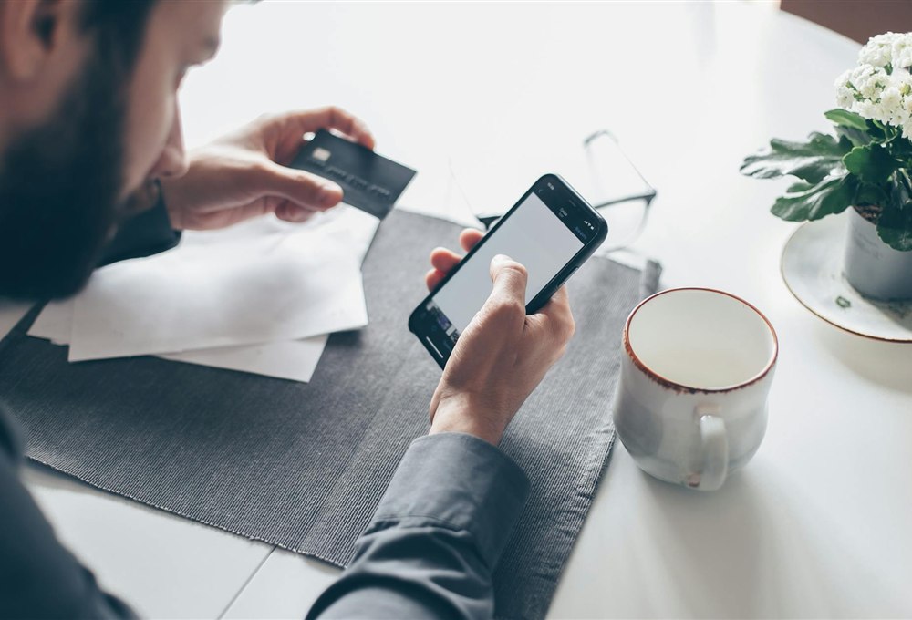 Person applying online for a no credit check loan in Canada on a smartphone