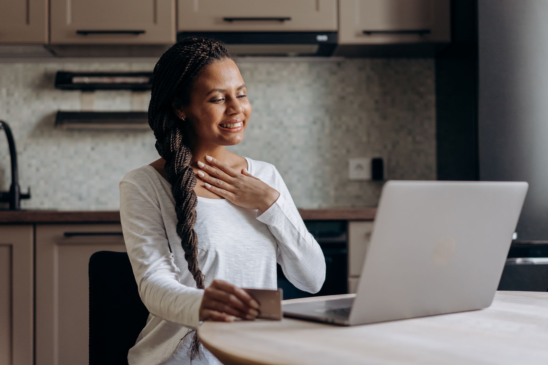 Smiling woman using laptop to apply for a $100 no credit check loan Canada