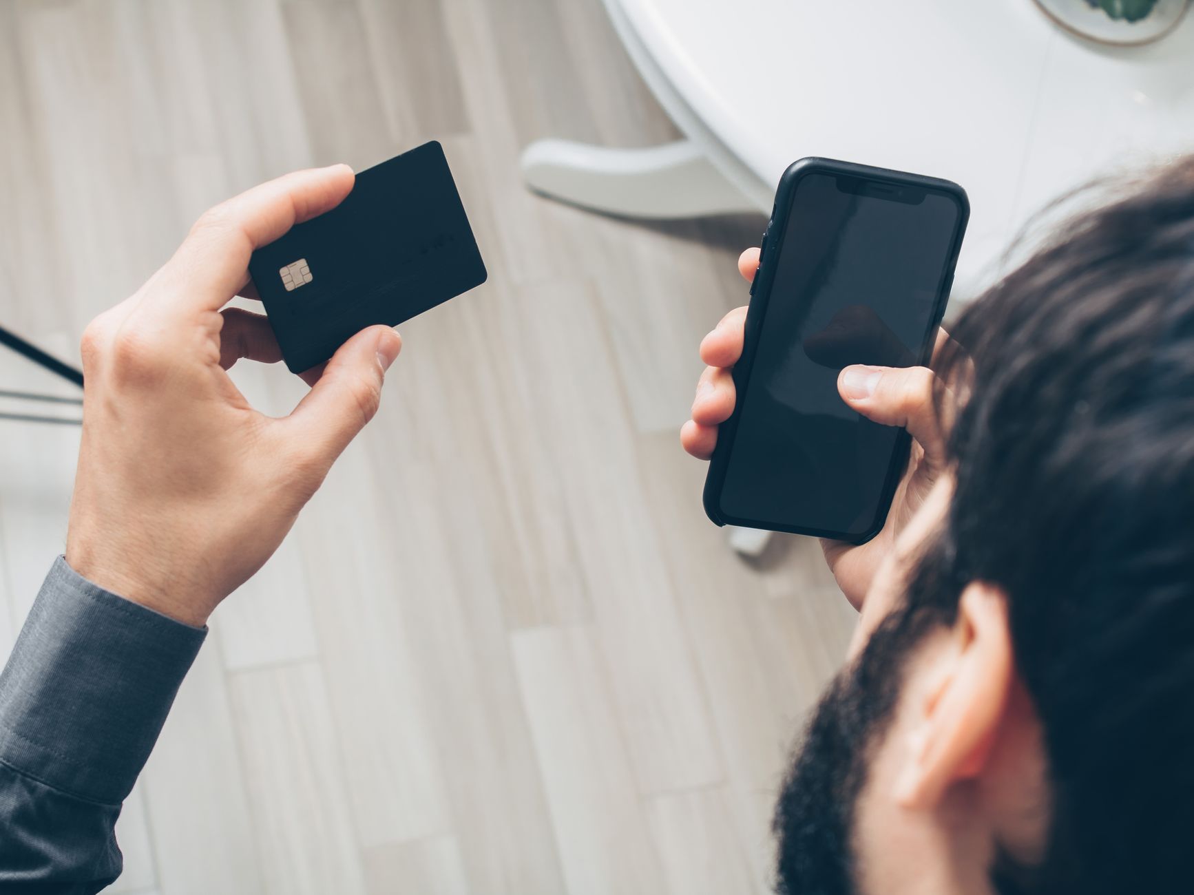 Man holding smartphone and credit card applying for no credit check loan