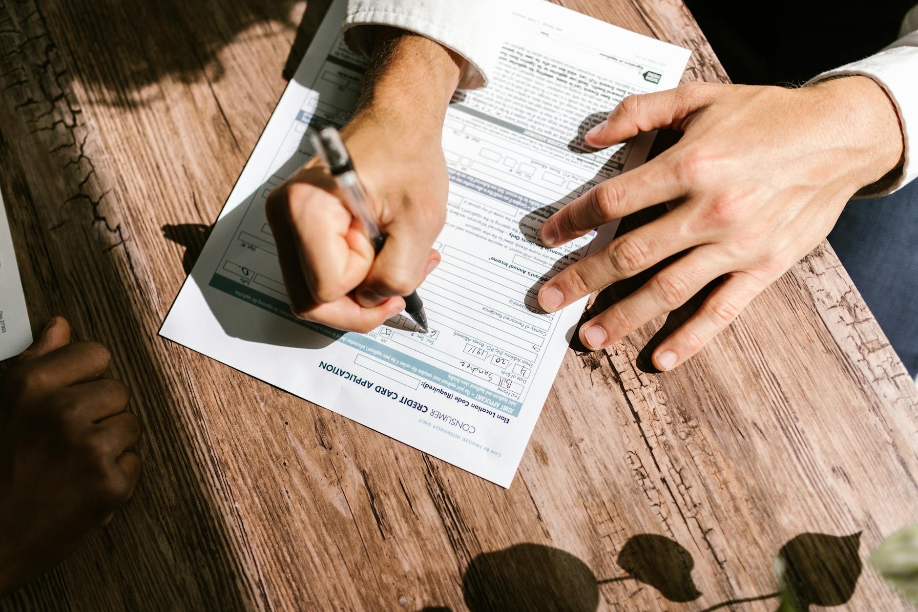 Hands filling out loan credit application form Canada