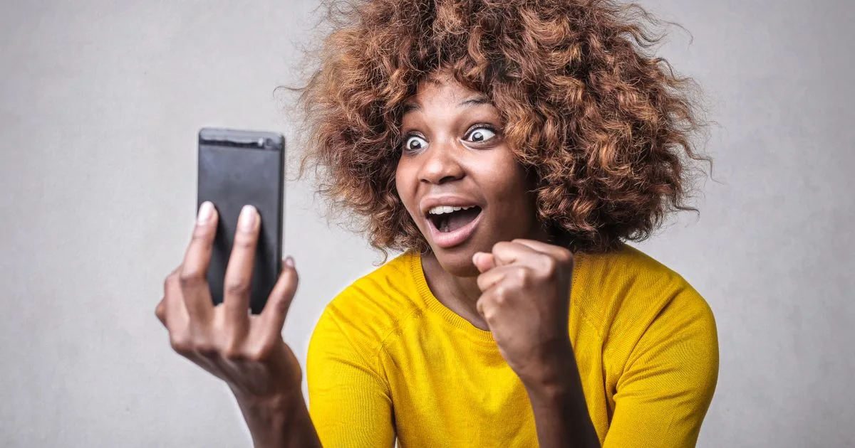 Woman reacting to an instant loan approval decision on her phone