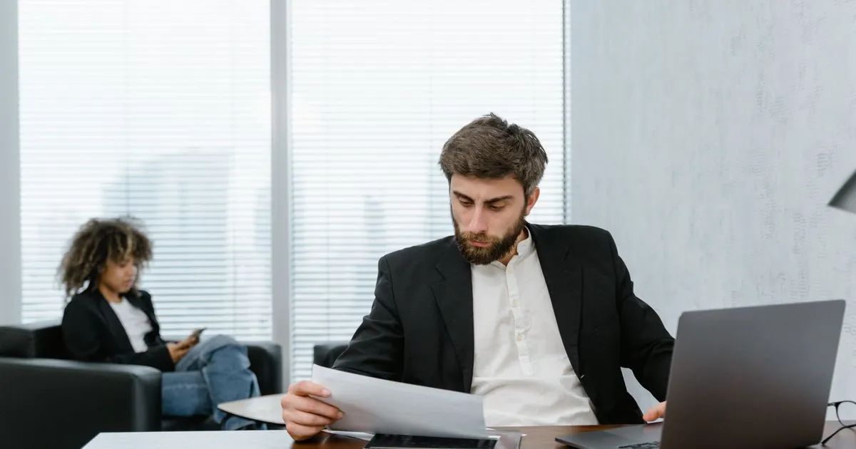 High risk loans application being reviewed by a lender at an office desk